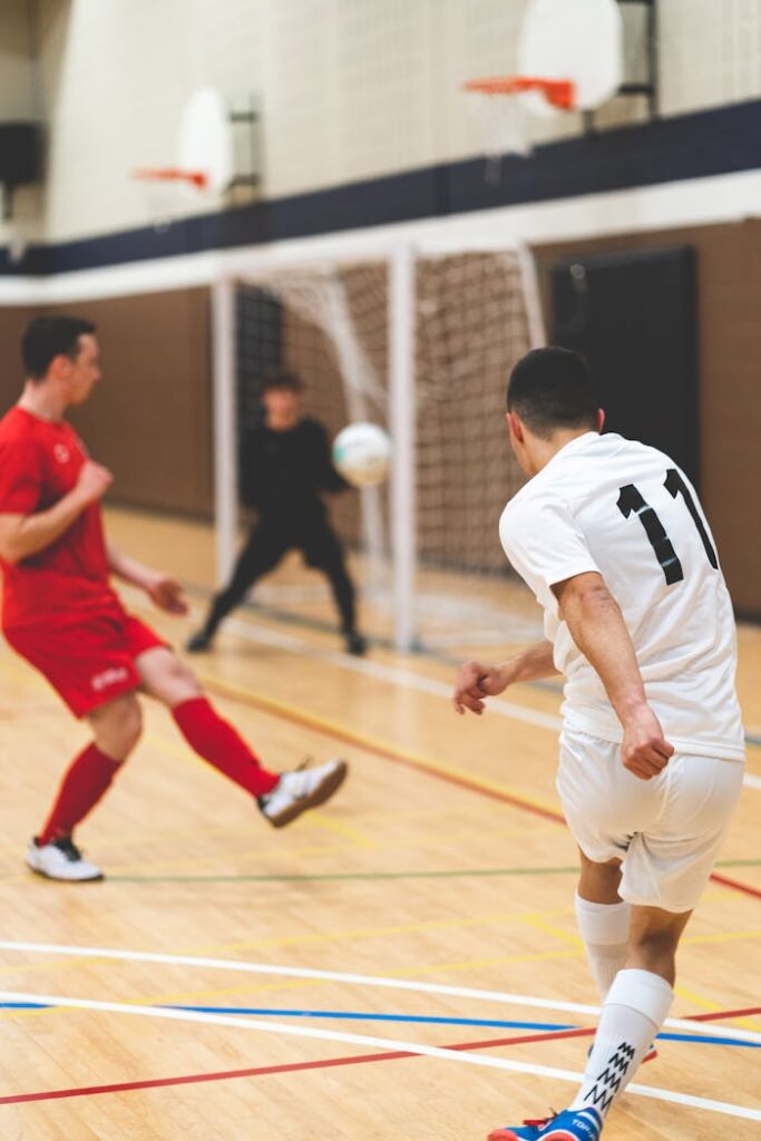 Offerings Action shot of an indoor soccer game with players in motion near the goal.