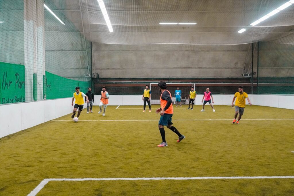 Home A lively indoor soccer game with diverse players actively engaging in the sport.